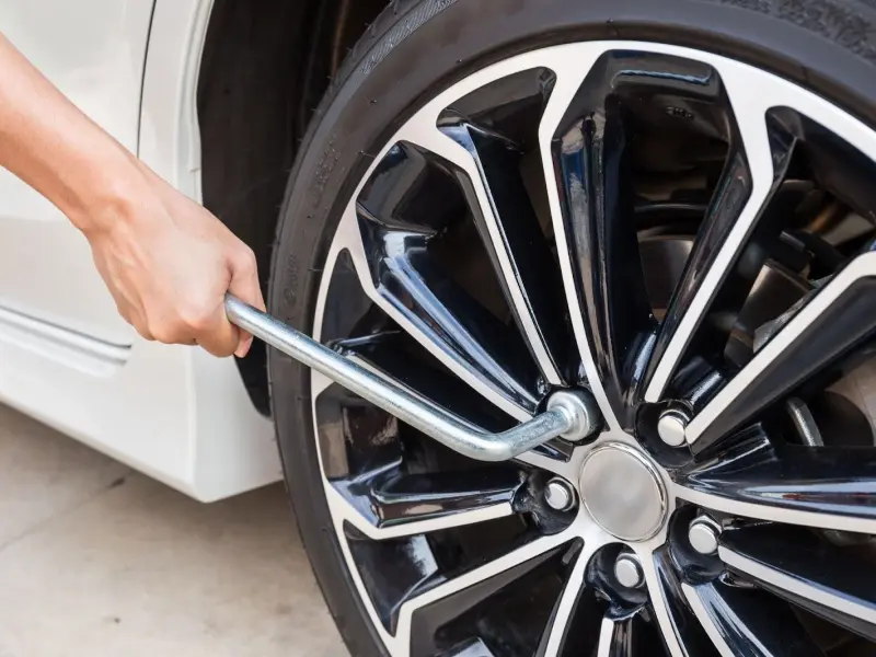 A man tightening a stud automotive on a car